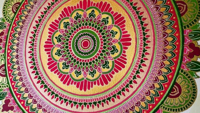 A vividly coloured mandala, decorative geometric patterns bloom from the centre in concentric circles.