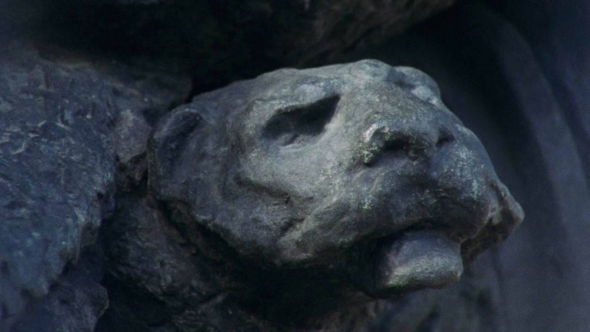A close up of a stone gargoyle's face.