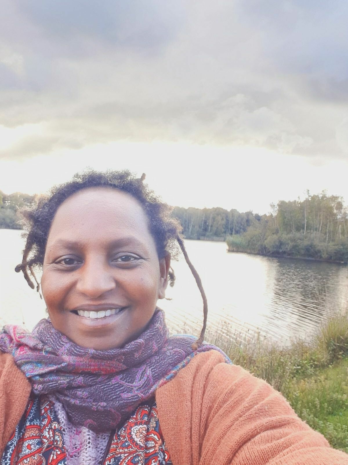 Tariqua Telahun Gorrissen smiles against a backdrop of a sunny lake