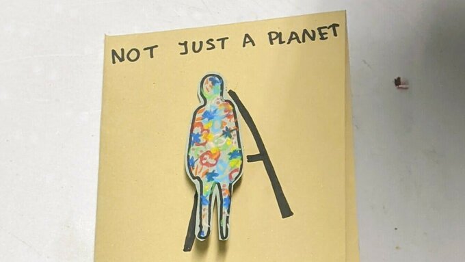 A hand-made zine that reads "not just a planet, HOME"