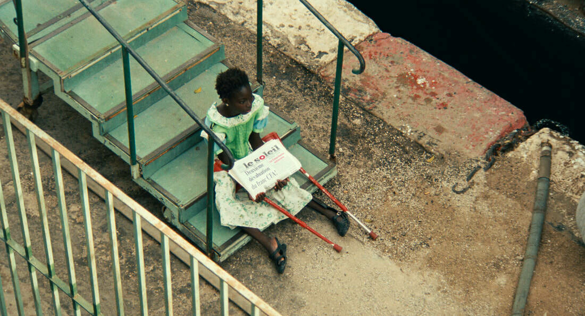Sili sat at the bottom of a set of steps cradling a stack of newspaper called Le Soleil in her arms.