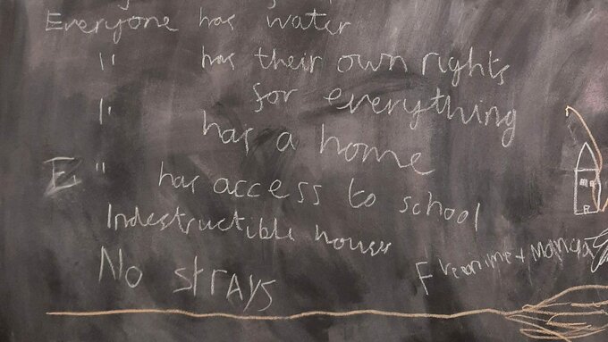 A black board with a child's writing of their hopes for the future.