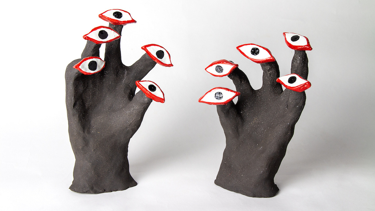 Two sculptures resembling a pair of hands. At the end of each finger are red rimmed eyes.