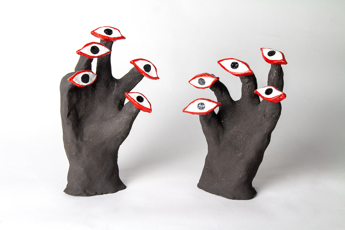 Two sculptures resembling a pair of hands. At the end of each finger are red rimmed eyes.