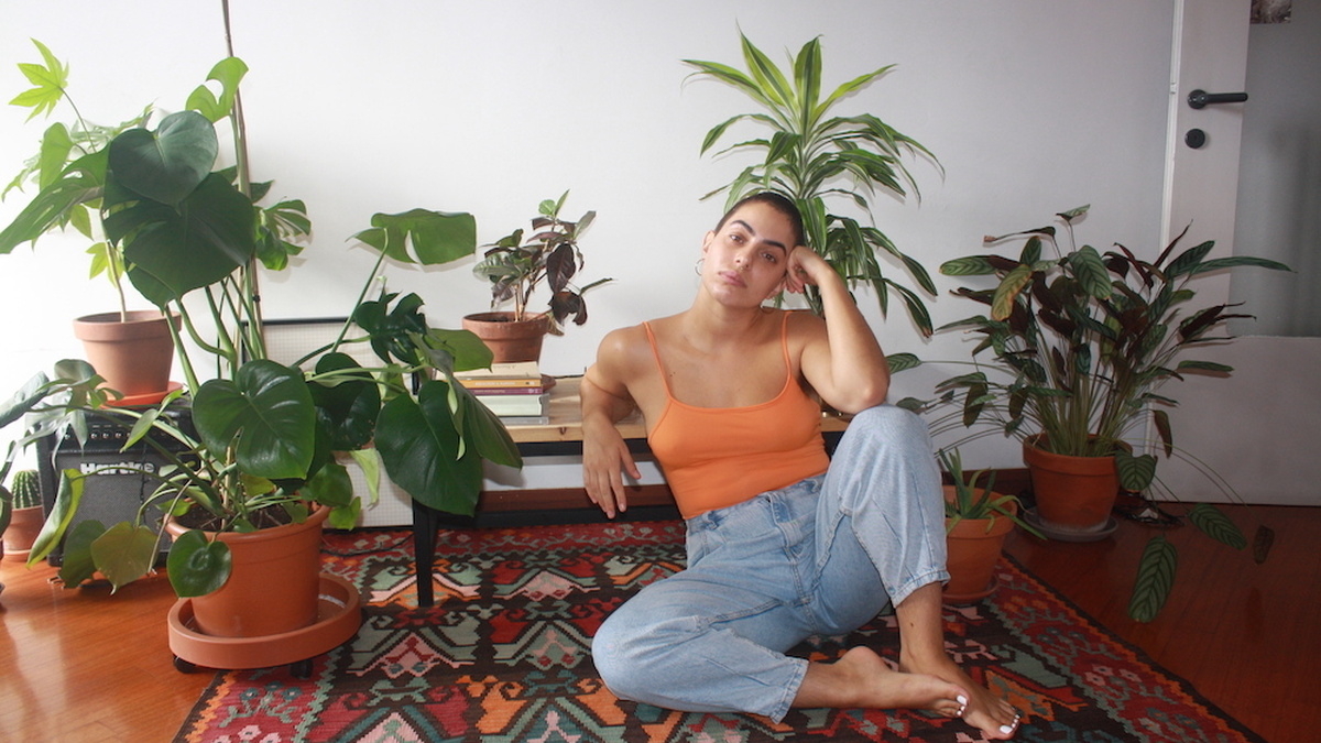 Giorgia reclines on a rug, surrounded by plants.