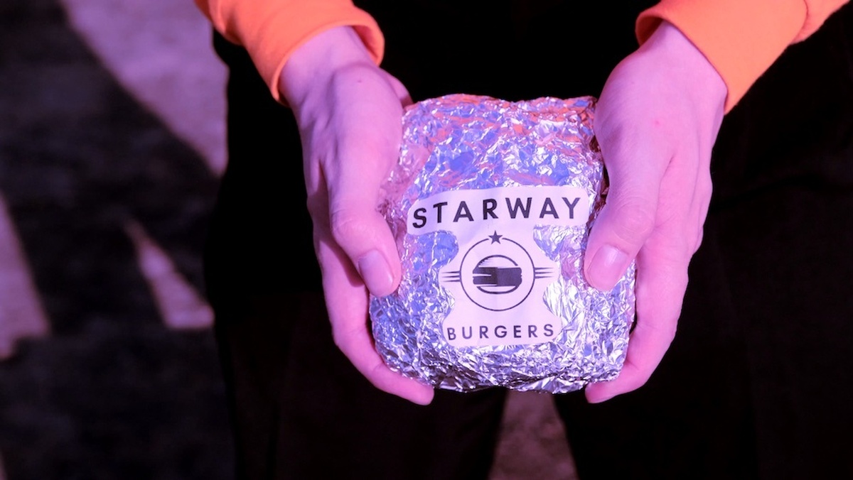 Hands holding a foil wrapped burger with a label reading "Starway Burgers".