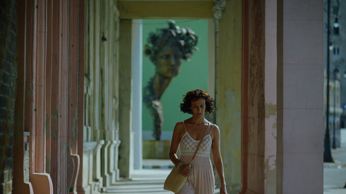 A person holding a bag walks through the streets of Havana.