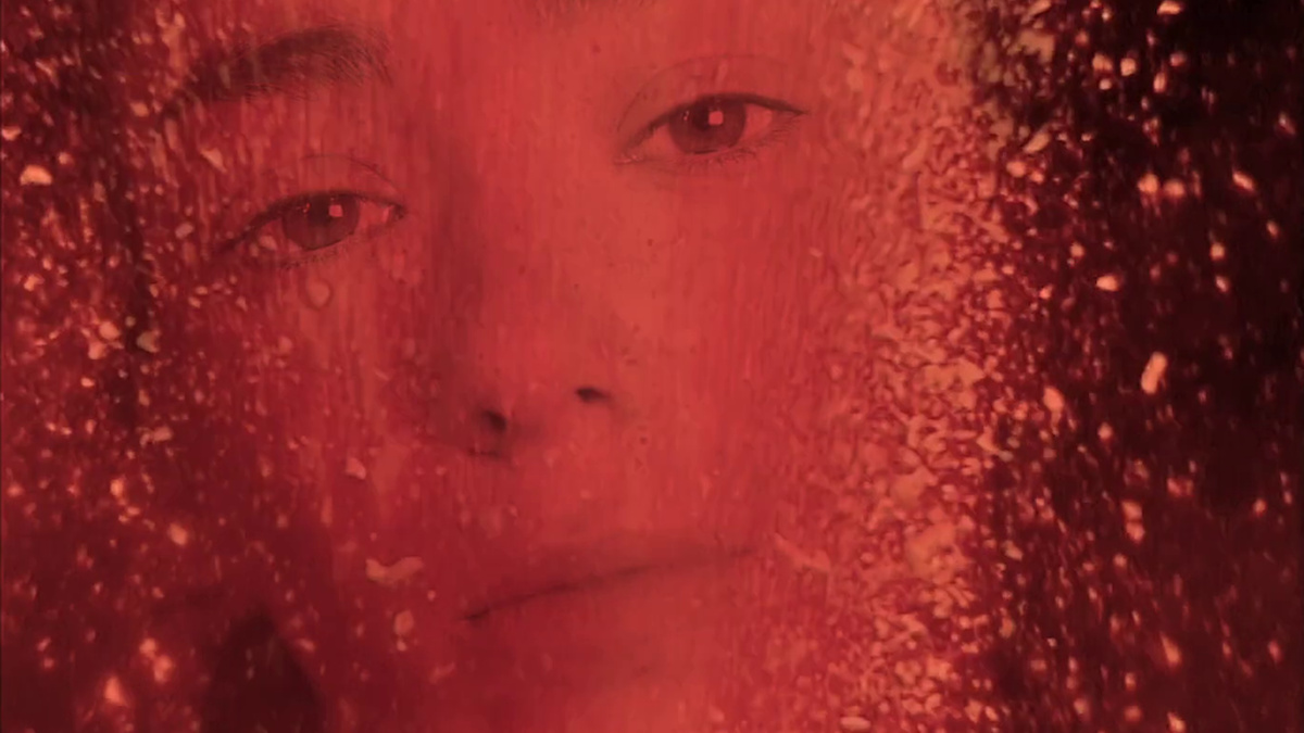 A face is almost obscured by a red film filter.