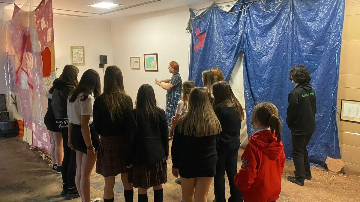 A class take a tour of an exhibition.