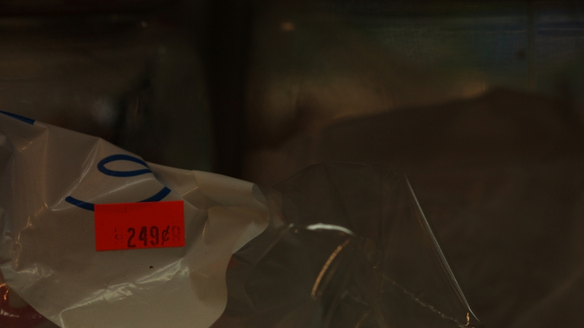 A dark photograph of a plastic bag with a red price sticker on it.
